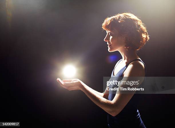 young woman with glowing light ball. - woman catching stock pictures, royalty-free photos & images