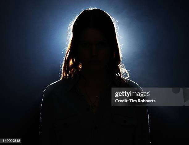 young woman in silhouette. - background light stock-fotos und bilder