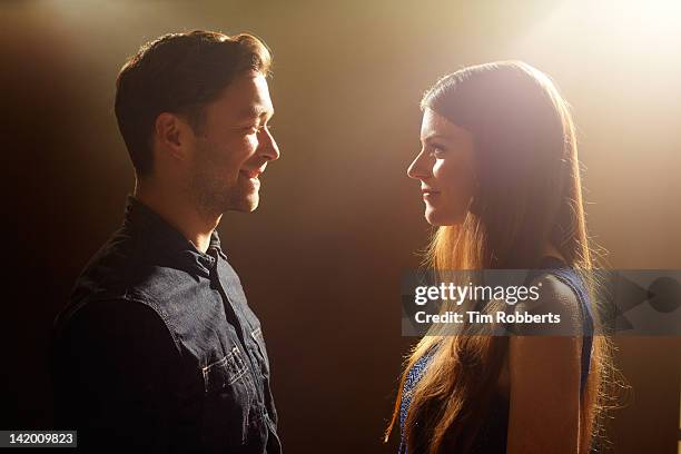 young couple looking at each other. - couple standing stockfoto's en -beelden