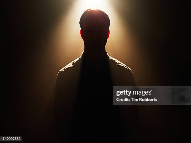 young man in silhouette. - mystery stock-fotos und bilder