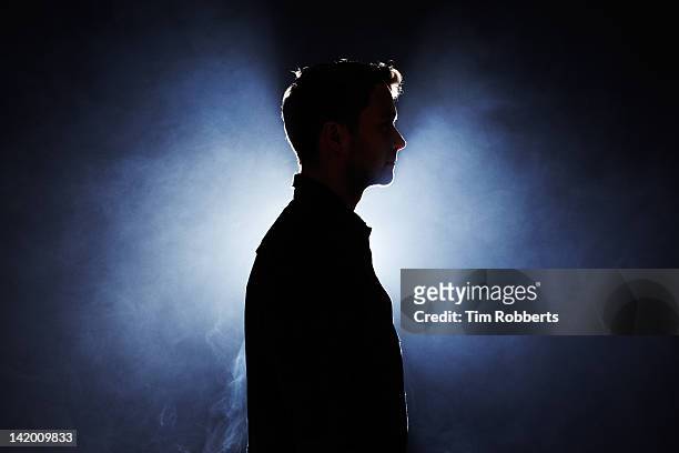 silhouette of young man looking ahead. - man silhouette stock pictures, royalty-free photos & images