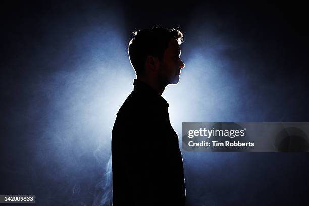 silhouette of young man looking ahead. - mystery bildbanksfoton och bilder