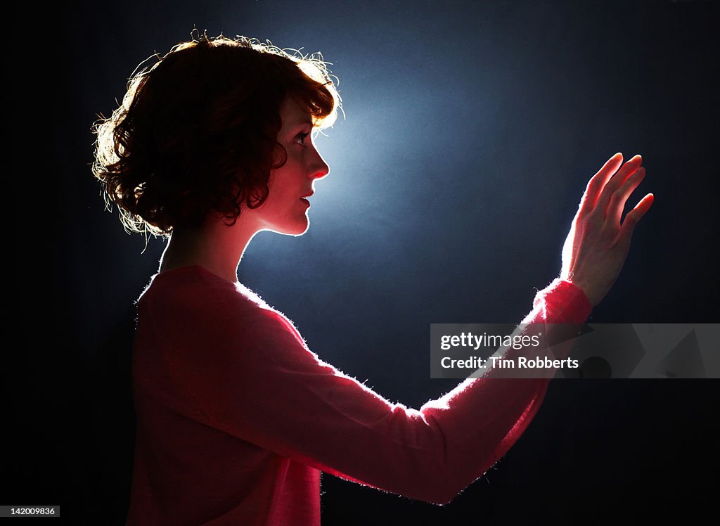 Young woman reaching her arm out.