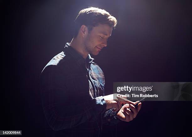 young man with smart phone. - smartphone dark stock pictures, royalty-free photos & images