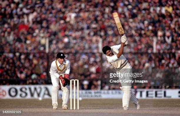 India batsman Kapil Dev hits out watched by Jack Richards during the 2nd One Day International between India and England on December 20th, 1981 in...