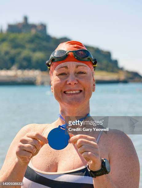 portrait of a female swimmer celebrating after a swimming event - medal of honor fotografías e imágenes de stock
