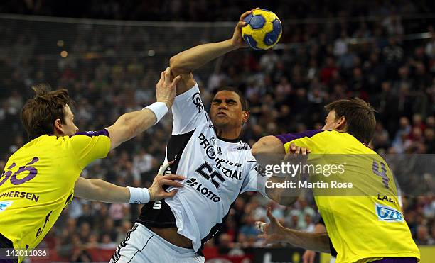 Daniel Narcisse of Kiel is challenged by Sven Christophersen and Torsten Laen of Berlin during the Toyota Handball Bundesliga match between THW Kiel...