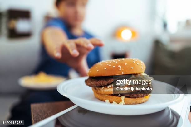 enjoying my favorite cheeseburger right now - boy belly stock pictures, royalty-free photos & images