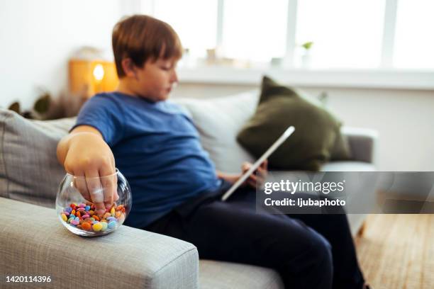 teenage boy eating candy during e-learning - candy jar stock pictures, royalty-free photos & images