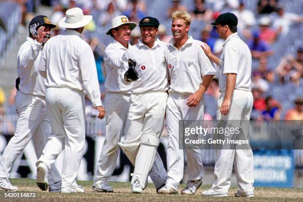 Australia leg spin bowler Shane Warne is congratulated by team mates Allan Border Ian Healy and Steve Waugh after taking one of his 7 second innings...