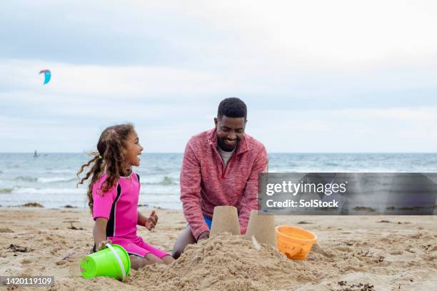 dad making sand castles with daughter - sandcastle stock pictures, royalty-free photos & images