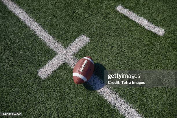 overhead view of american football ball on field - アメリカンフットボール場 ストックフォトと画像