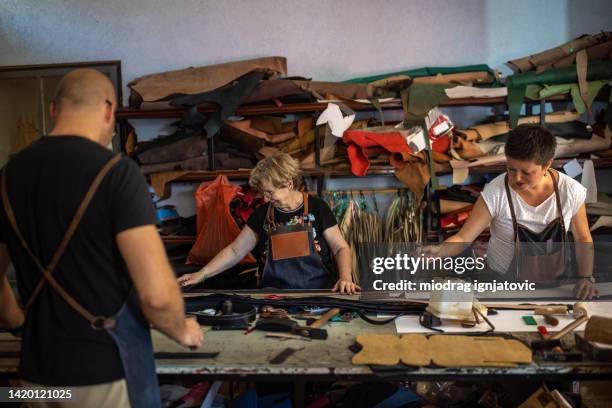 three people working in a leather workshop - leather belt stock pictures, royalty-free photos & images