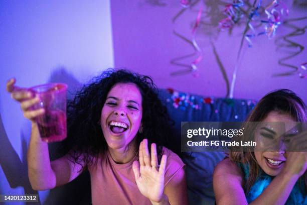 mid adult woman having fun and drinking beer with her friends at a party - friends tv show stock pictures, royalty-free photos & images