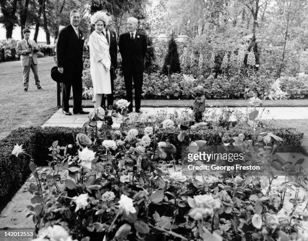 Queen Elizabeth II viewing a rose bed, exhibited by 'Popular Gardening' magazine, during a tour of the Chelsea Flower Show, London, 22nd May 1962.