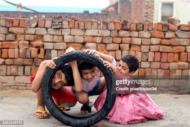 verspielte arme kinder im grundschulalter porträtieren gemeinsam zu hause - entwicklungsland stock-fotos und bilder