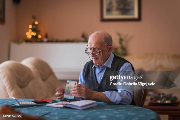 elderly man concentrating on monthly expenses and the money he got left - serbia eu stock pictures, royalty-free photos & images