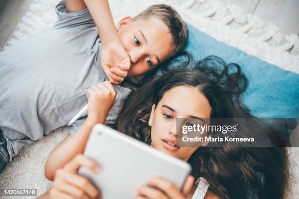 brother and sister using digital tablet at home. - 13 year old cute boys stock pictures, royalty-free photos & images