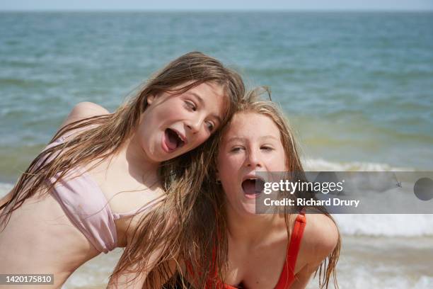 two girls messing about at the beach - junge 13 jahre oberkörper strand stock-fotos und bilder