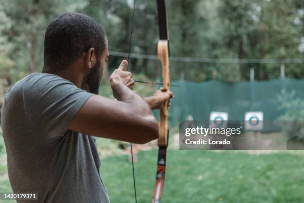 black man trying archery - archery target stock pictures, royalty-free photos & images