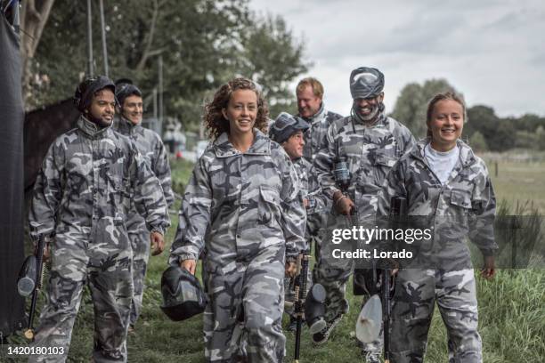 a mixed race, age and gender paintball team on their way to the field - army stock pictures, royalty-free photos & images