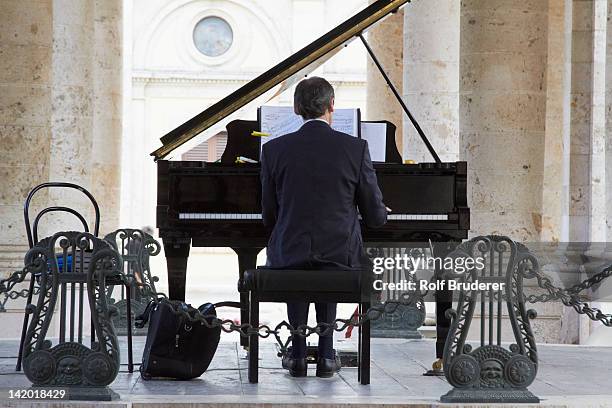 pianist playing piano outdoors - piano stock pictures, royalty-free photos & images