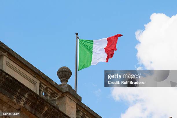 italian flag fluttering on rooftop - bandera italiana fotografías e imágenes de stock