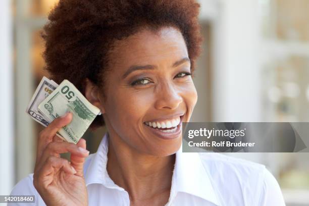 african american woman holding 50 dollar bill - 50 dollars stock pictures, royalty-free photos & images