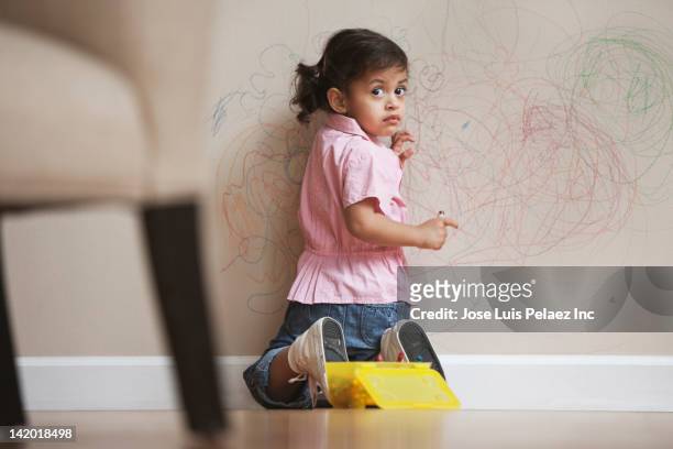 hispanic girl drawing on wall - misbehaving children stock pictures, royalty-free photos & images