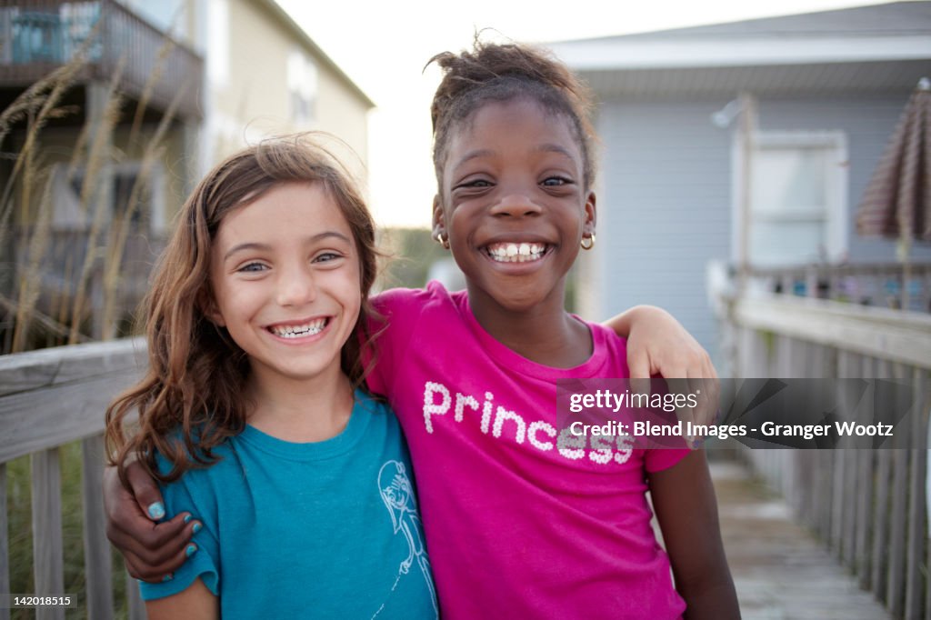 Grinning girls hugging outdoors