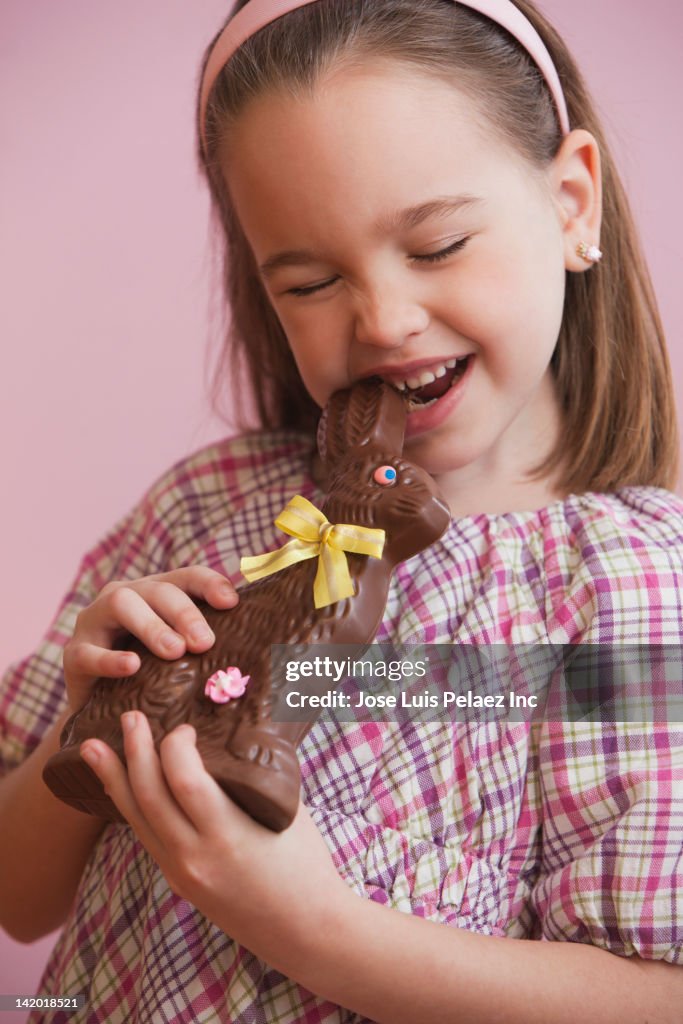 Caucasian girl eating chocolate Easter bunny