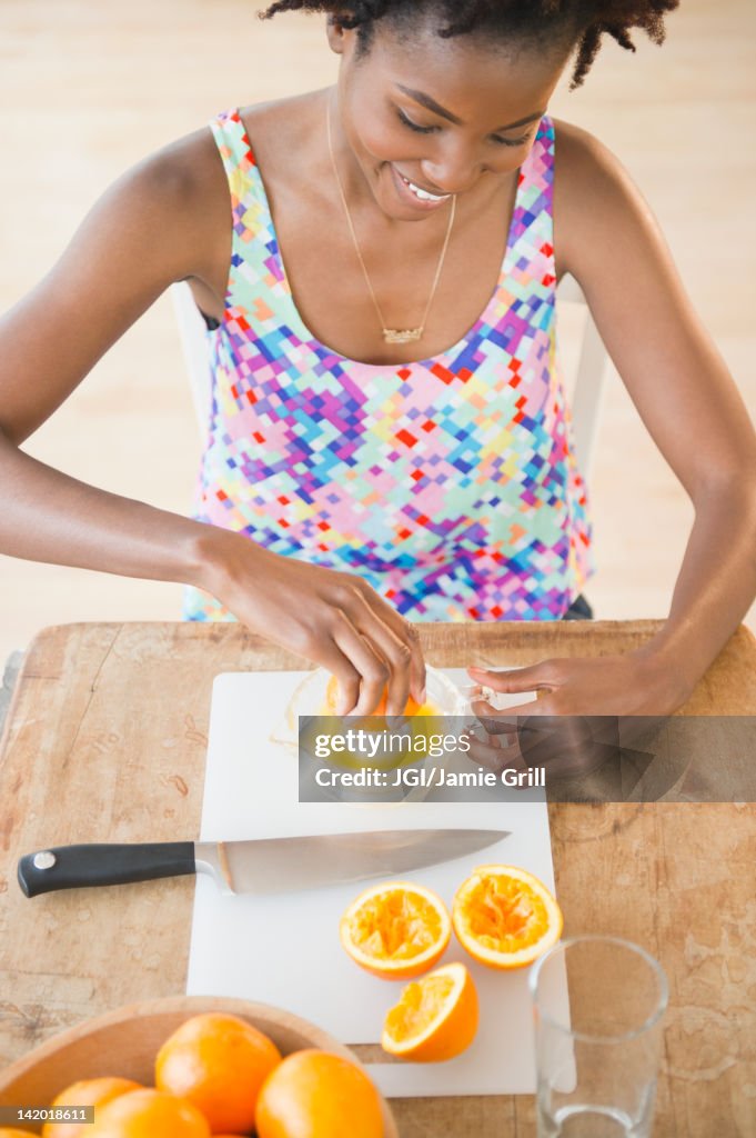 Black woman squeezing fresh orange juice