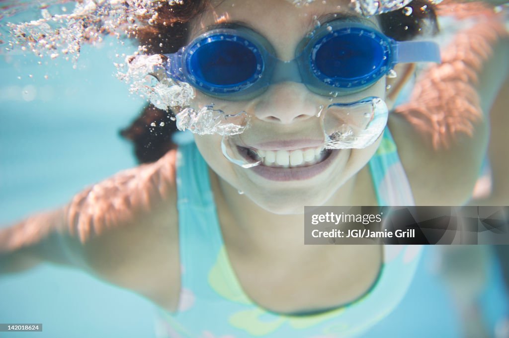 Hispanic girl swimming under water