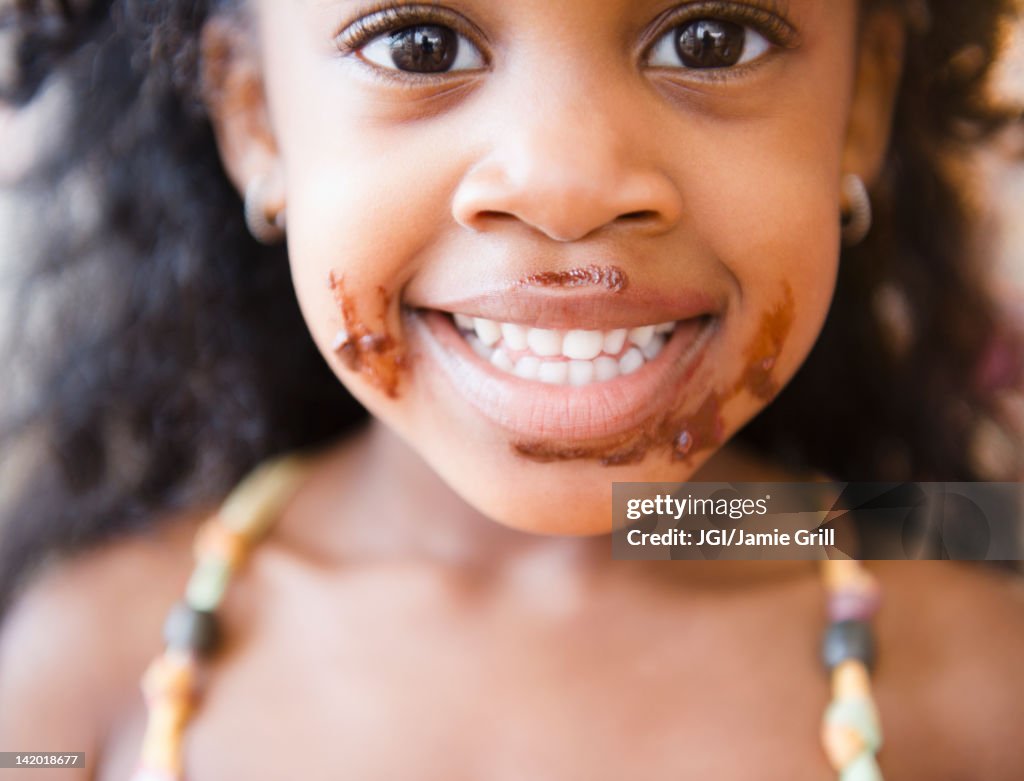 Mixed race girl with chocolate on her face