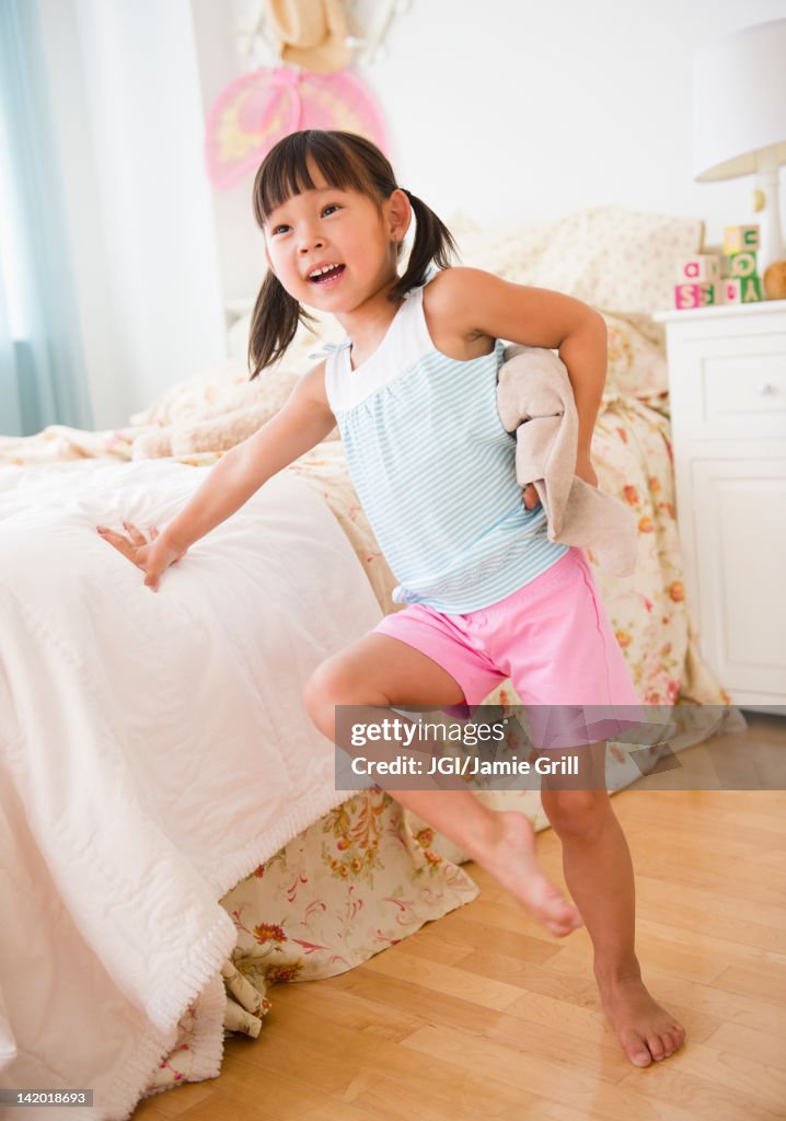 Korean girl leaning against bed in bedroom