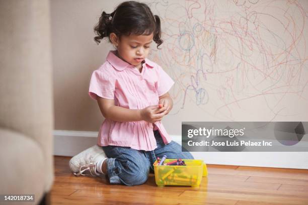 hispanic girl drawing on wall - kid holding crayons stockfoto's en -beelden