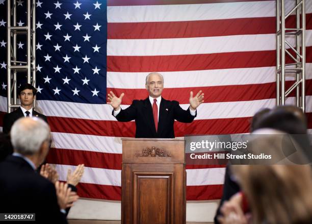 caucasian politician making speech at podium - politician stockfoto's en -beelden