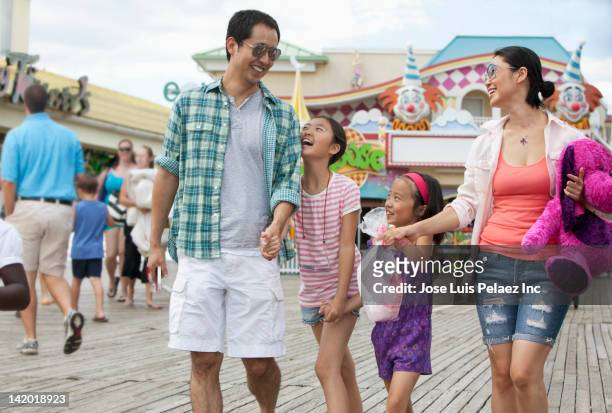 family enjoying amusement park - bulevar fotografías e imágenes de stock