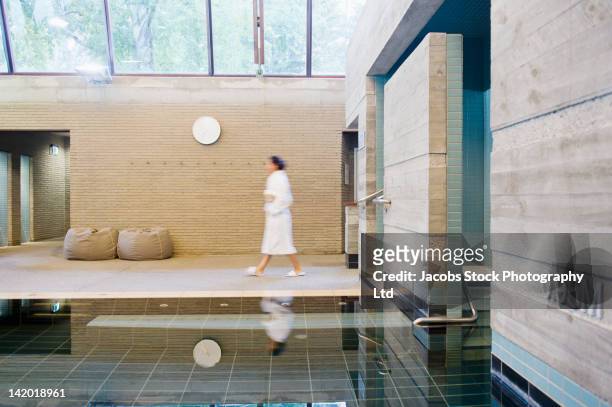 hispanic woman in bathrobe walking in spa - health spa stock pictures, royalty-free photos & images