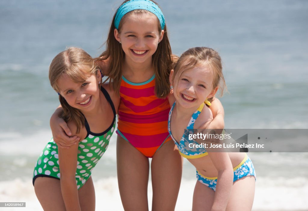 Caucasian girls hugging on beach