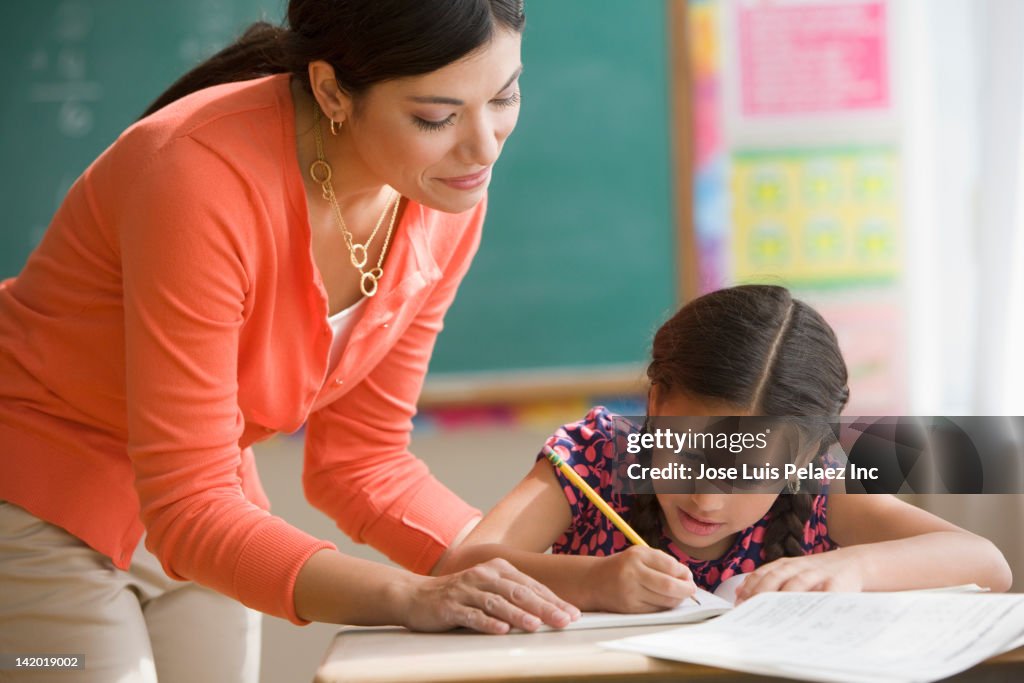 Teacher helping student in classroom