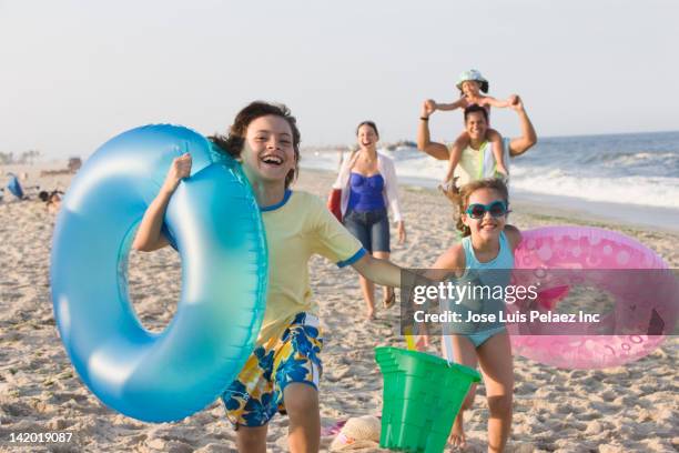 hispanic family enjoying beach together - children in summer photos et images de collection