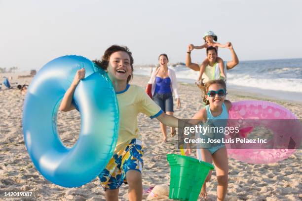 hispanic family enjoying beach together - beach kids stock pictures, royalty-free photos & images