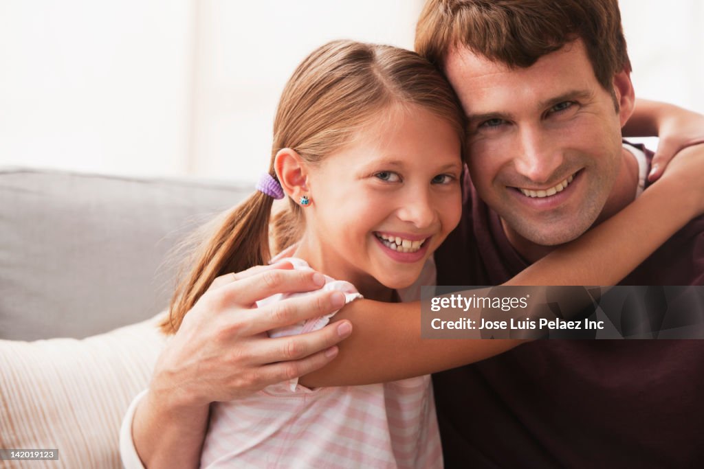 Caucasian father and daughter hugging