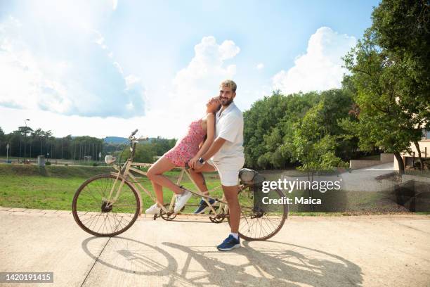 giovani coppie che guidano la bicicletta tandem - tandem bicycle foto e immagini stock