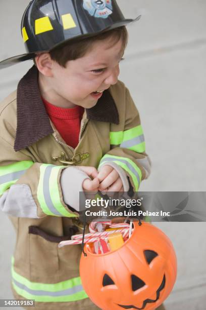 caucasian boy dressed in fireman halloween costume - boy fireman costume stock pictures, royalty-free photos & images