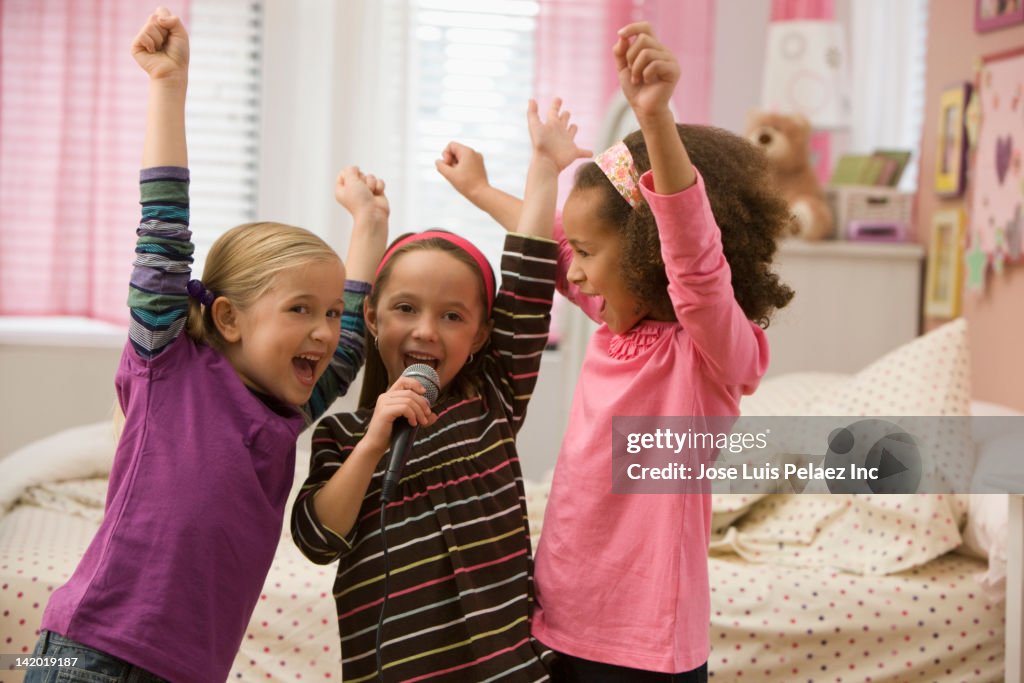 Girls singing into microphone together
