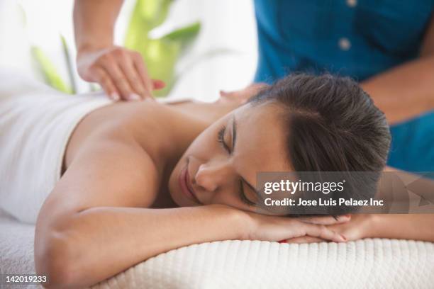 hispanic woman having massage - massaggiare foto e immagini stock