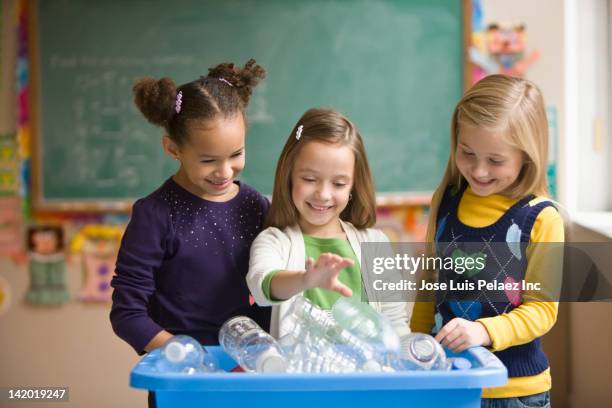 students recycling plastic bottles in classroom - putting indoors stock pictures, royalty-free photos & images