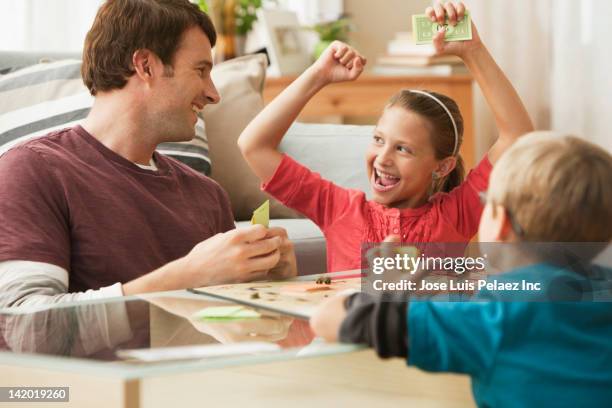 caucasian father and children playing board game - boardgame stockfoto's en -beelden